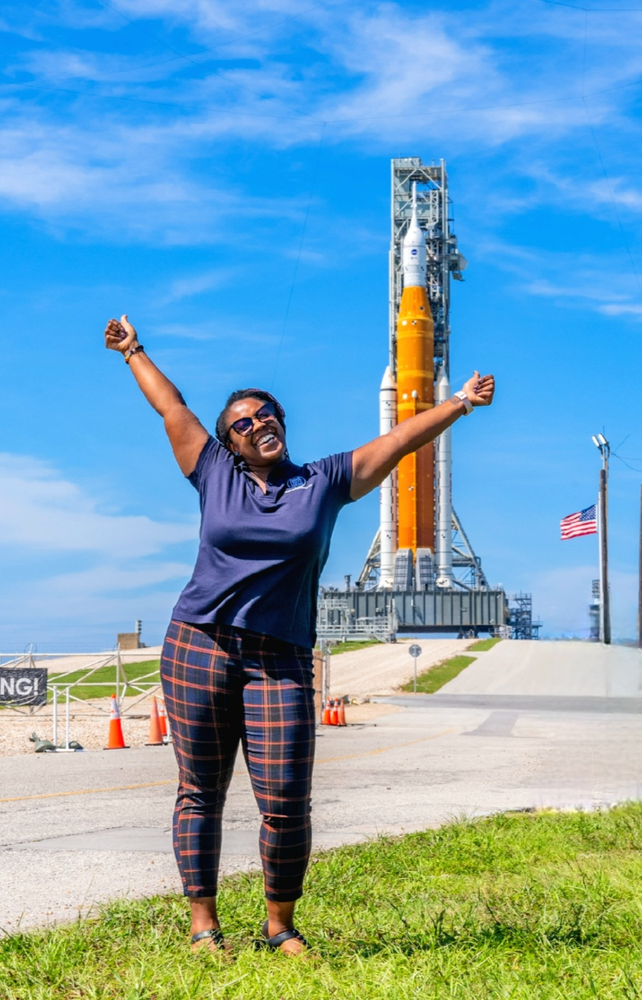 Chasity Williams in front of NASA’s Orion spacecraft atop the Space Launch System rocket at Kennedy Space Center.
